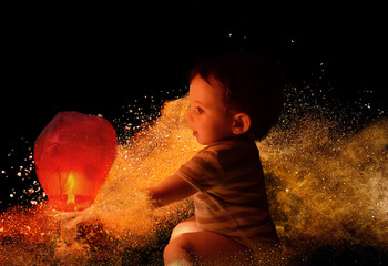 A kid holds a sky lantern for making a wish  