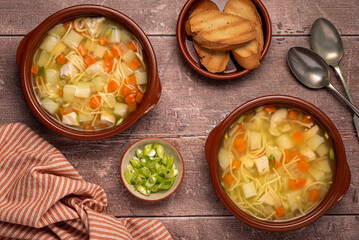 Food photography of soup, broth, noodle, potato, chicken, carrot