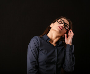 Beautiful thinking serious business woman looking up and scratching her head and deciding riddle in...