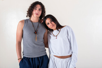 Portrait of a young couple dressed in yoga clothes looking ti the camera white background.
