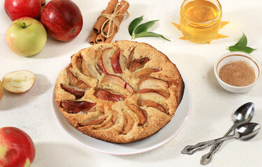 Kitchen background with apple pie, honey, apples, spices, cozy warm concept, hello autumn, hygge style, modern bakery advertisement, selective focus, top view,