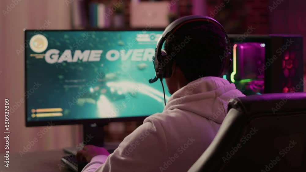Poster over shoulder view of gamer feeling unhappy after losing difficult level in online space shooter on 