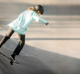 young teen girl having fun and practicing in a skate park, urban background, healthy active...