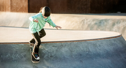 young teen girl having fun and practicing in a skate park, urban background, healthy active...