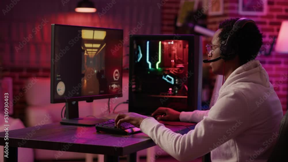 Poster handheld shot of african american man using pc gaming setup relaxing playing first person shooter in
