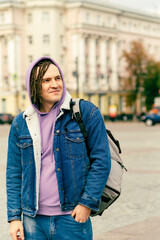 Fototapeta premium Young handsome man with dreadlocks in casual clothes posing on busy street in downtown.