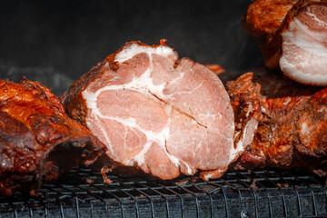 Smoked pork neck. Street food. Meat in the smokehouse. Dark crust with spices. Natural meat product produced by traditional methods
