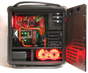 Obraz premium Modern water-cooled desktop computer with red LED backlight with open lid, on a white background. System unit with components.