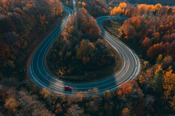 aerial photography of curved road on autumn, beautiful curved pass with vehicles and colorful...