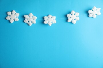 Beautiful decorative snowflakes hanging on light blue background, space for text