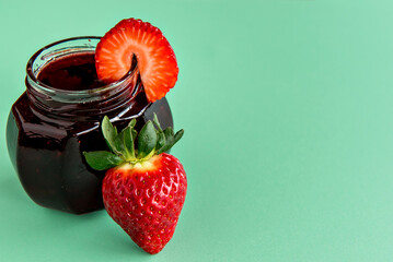 Delicious strawberry jam on green background