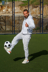 Young male soccer player juggles a ball on a soccer field