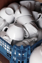 Naklejka na ściany i meble Pile of clean white cups in plastic box. Close up.