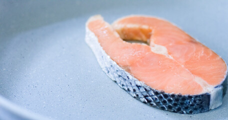 Close-up of freshly colored raw salmon placed in a pan.