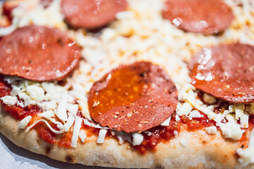 healthy plant-based food, homemade pizza with dairy-free cheese and vegan pepperoni before getting cooked
