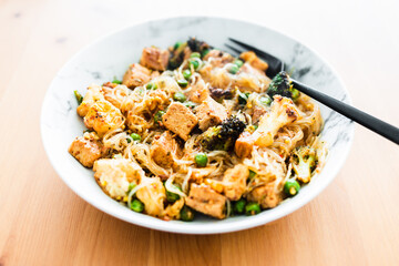 healthy plant-based food, vegan noodles stir fry with broccoli peas and marinated tofu chunks