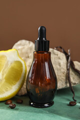 Bottle with essential oil and lemon on table, closeup