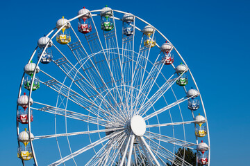 Closeup of A Colorful Ferris Wheel Over Blue Sky.