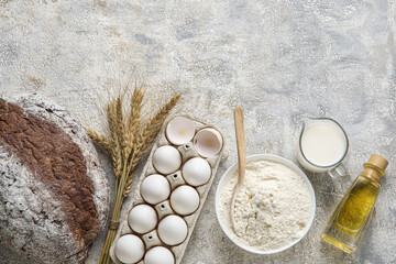 Ingredients for baking and fresh bread on light background