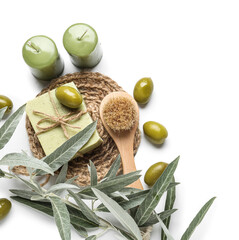 Olive soap bar, candles, massage brush and tree branch on white background