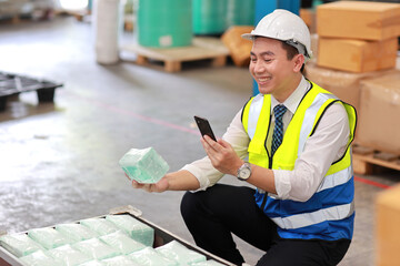 Asian technician engineer and businessman in protective uniform with mobile phone inspecting quality of mask and medical face mask production line in factory manufacturing industry and factory concept