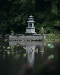 Fototapeta na wymiar a small stupa on the lake near Bich Dong Pagoda