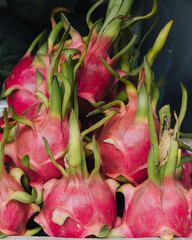 A close-up of pink dragon fruits on a food market stall in Hoi An, Vietnam.