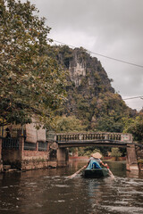 Ninh Binh, Vietnam - March 3rd, 2020 : tourist boat on the Ha Long Bay on land in Tam Coc, Vietnam with karst mountains in the background