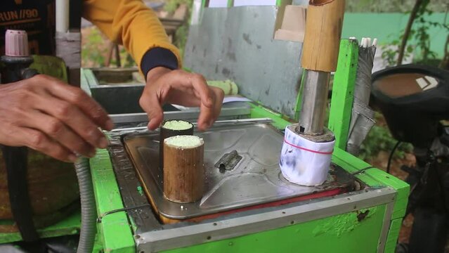 "putu" cake, a traditional Indonesia food, cooked with steaming hot steam water using a tool in the form of pieces of bamboo.