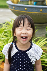 A happy Asian girl laughing with white beautiful teeth in the park.