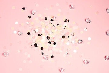 Colorful festive round confetti dots and crystals on pink background. Holiday greeting card.