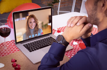 Caucasian couple making valentines date video call the woman on laptop screen smiling