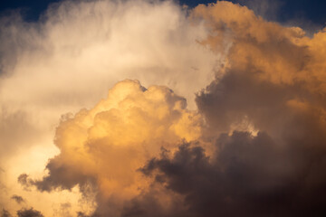 Richly multicolored white and yellow puffy clouds at sunset