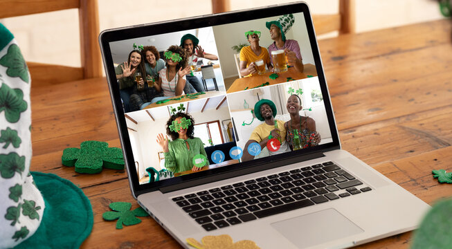 Diverse friends in costumes making st patrick's day video call displayed on laptop screen at home