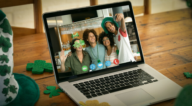 Diverse group of friends on laptop screen making st patrick's day video call taking selfie at a bar - Powered by Adobe