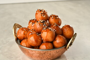 luqaimat or lokma. Freshly fried Lokma (luqma - arabic) piled high a popular middle eastern dessert of small dough balls deep fried then coated in sugar or honey syrup
