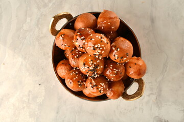 luqaimat or lokma. Freshly fried Lokma (luqma - arabic) piled high a popular middle eastern dessert of small dough balls deep fried then coated in sugar or honey syrup
