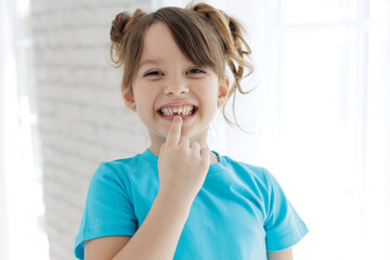 The child has lost a tooth. Little girl without a tooth. The first tooth fell out. High quality photo - 530958012