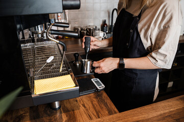 Portrait of professional female barman making coffee and modern coffee bar.