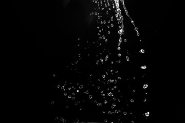 Naklejka na ściany i meble water splashes isolated on black background. white jets with drops