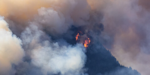 BC Forest Fire and Smoke over the mountain near Hope during a hot sunny summer day. British Columbia, Canada. Wildfire natural disaster