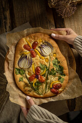 Garden art focaccia bread with vegetables, greens, herbs - beautiful flower composition on homemade...