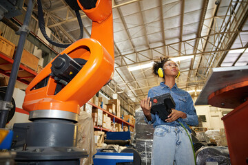 factory worker or engineer operating remote switch controller to control robot machine in the...