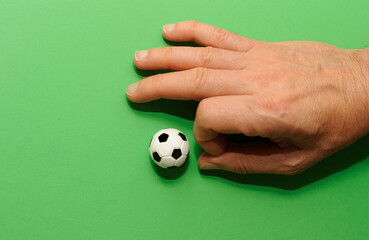 male hand finger football with a miniature toy soccer ball