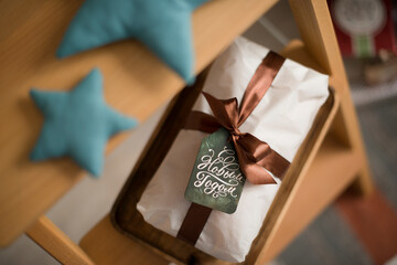 A Christmas bundle decorated with a ribbon lies with the tag 