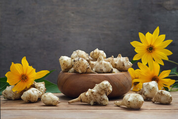 Roots, flowers and leaves of fresh organic topinambur or jerusalem artichoke Helianthus tuberosus. Tubers of sunroot, sunchoke or earth apple. Diabetic friendly food vegetable with inulin.