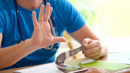 Gynecologist examines ultrasound of uterus of patient in medical office holds ahand with pen