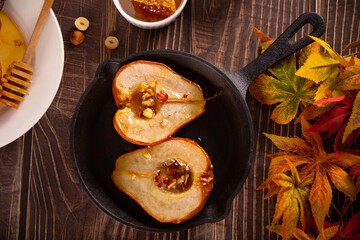 Honey or maple syrup roast pears with walnuts. Vegetarian diet health delicious dessert.