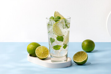 Delicious refreshing summer mojito with ice, lime and mint in a glass with grops. Sunshine. Copy space. Cold lemonade, tonic.