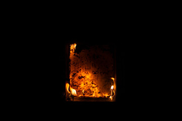 window leaf from a wooden window on fire close-up on a black isolated background